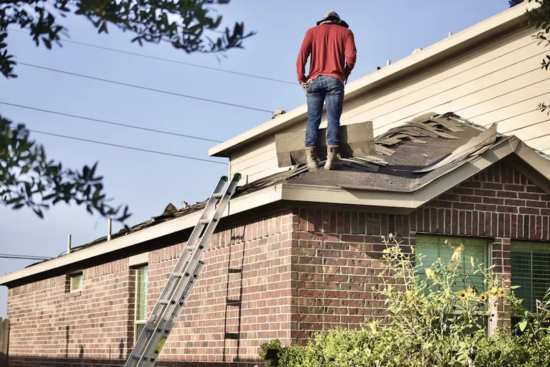 Professional roofer working on a residential roof in Monett